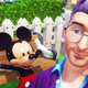 Mickey Mouse cheers behind a man with purple hair and glasses.